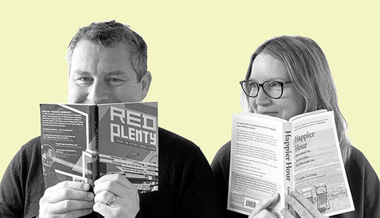Book subscription box founders Emma and Dave sitting together reading books